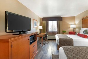 A hotel room with a bed, a desk, a television, and an air conditioning unit. - Best Western Prineville Inn (Prineville)