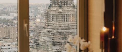 Blick aus einem Fenster auf eine Stadtansicht mit einem markanten Gebäude, das eine Kuppel und Gerüstaufstellung zeigt.