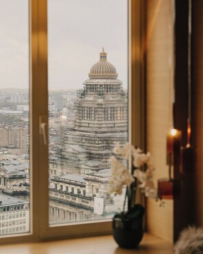 A view from a window overlooking a cityscape with a prominent building featuring a dome and scaffolding. - The Hotel (Brussels)