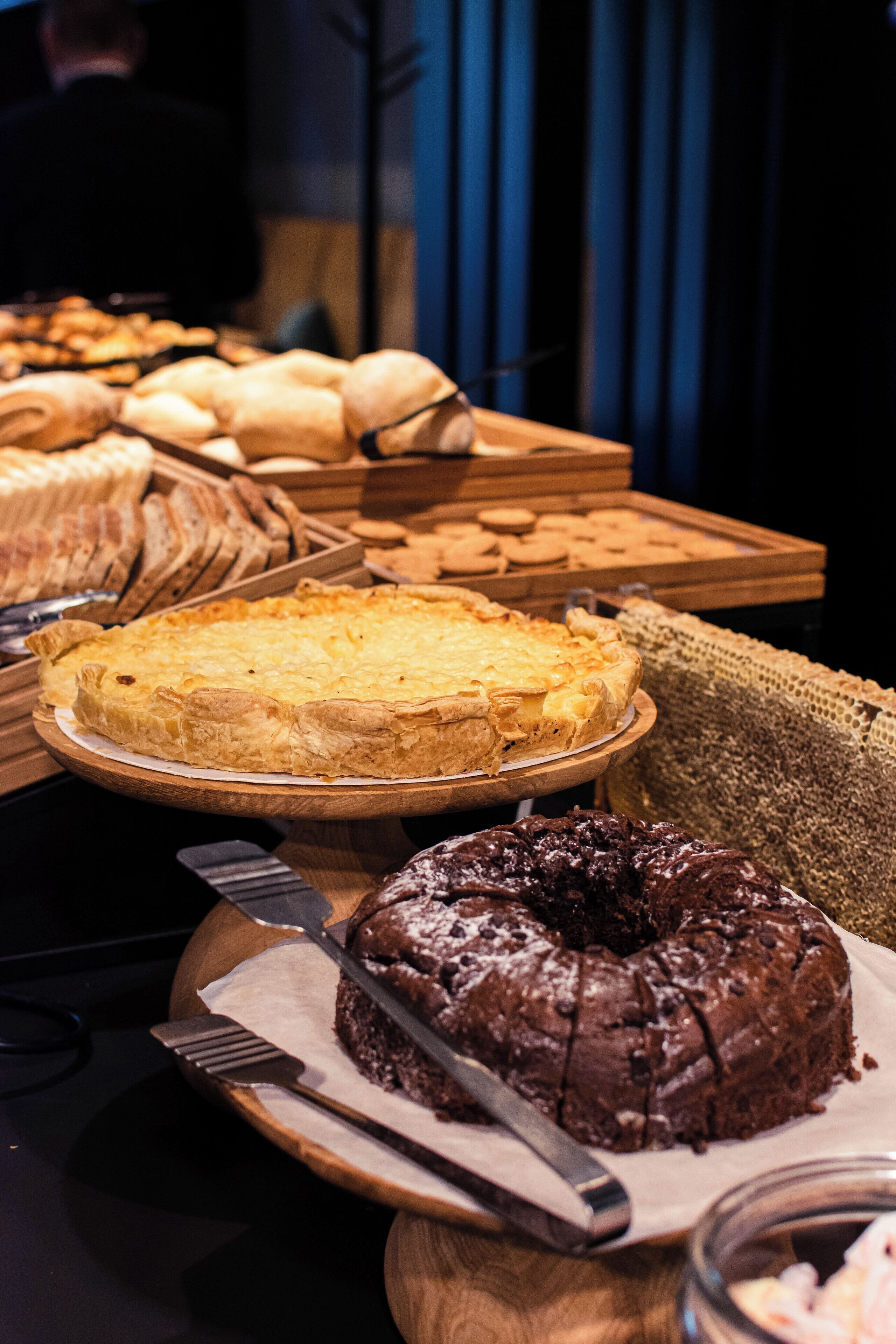 A variety of baked goods on display, including a pie, a cake, and bread.
