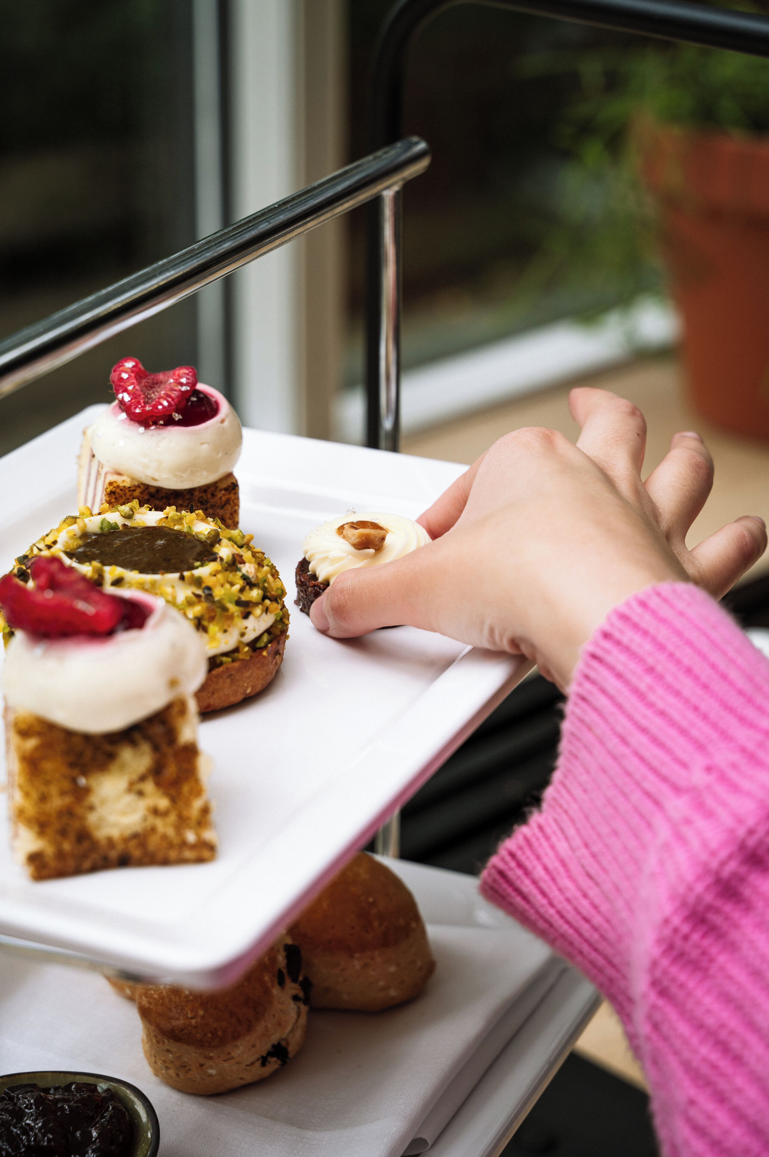 A tray with various pastries on a table near a window.
