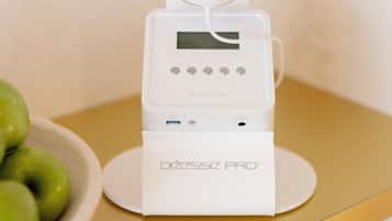 A white device labeled "DÉCASSZ PRO" on a table with a bowl of green apples beside it.