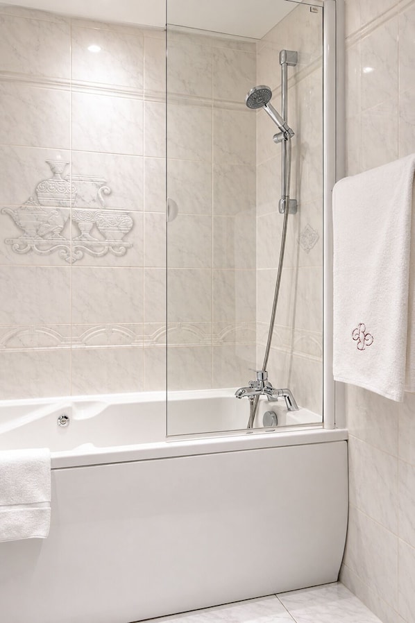 A modern bathroom with a glass-enclosed shower, a bathtub, and a towel rack.