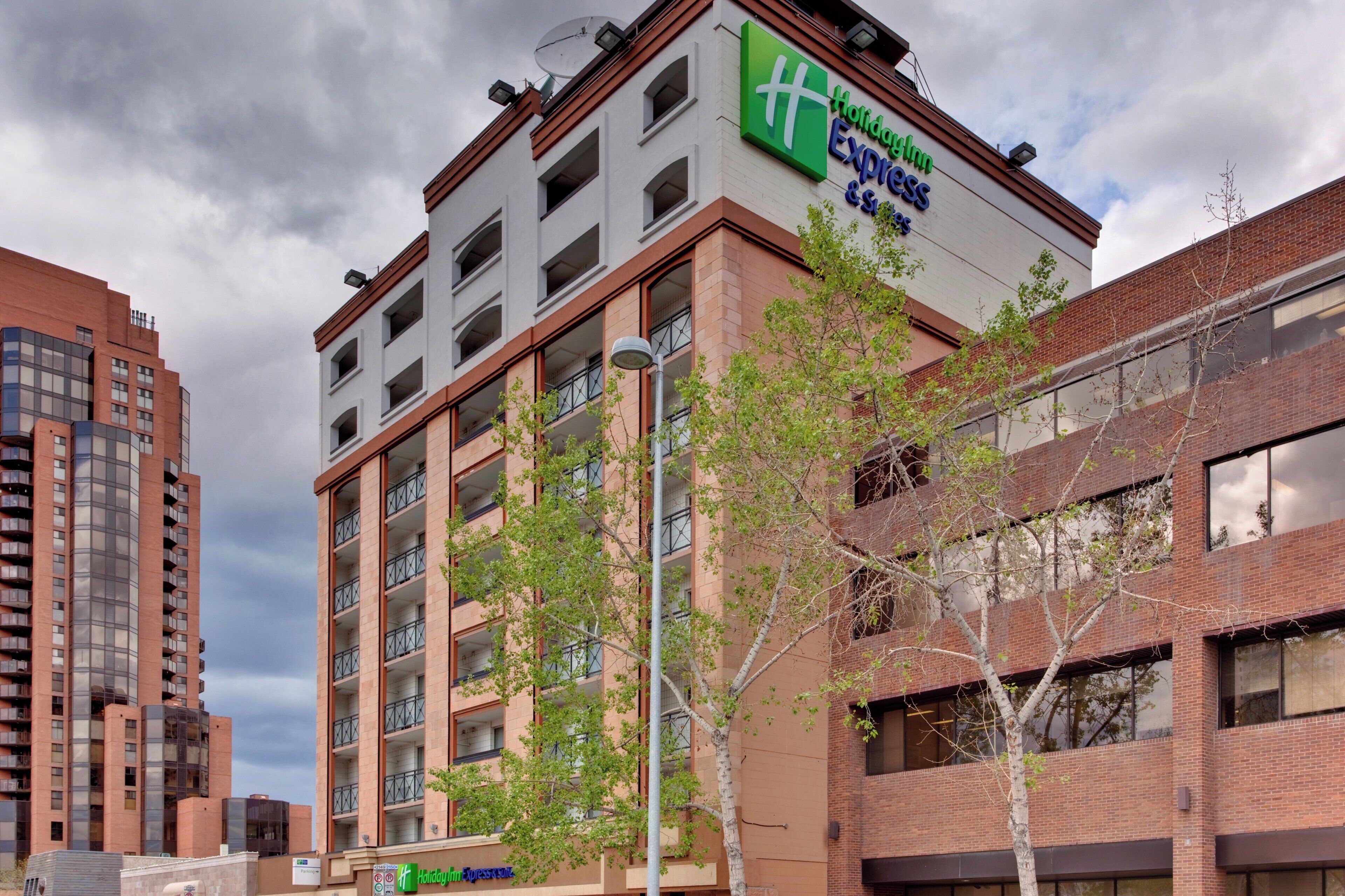 Een Holiday Inn Express gebouw met een modern architectonisch ontwerp, met meerdere balkons en een helder uitzicht op de omgeving.