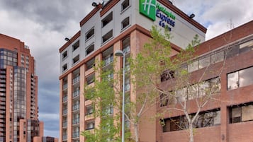 Een Holiday Inn Express gebouw met een modern architectonisch ontwerp, met meerdere balkons en een helder uitzicht op de omgeving.