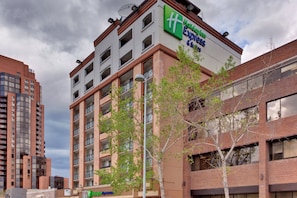 A Holiday Inn Express building with a modern architectural design, featuring multiple balconies and a clear view of the surrounding urban environment. - Holiday Inn Express Hotel & Suites Calgary by IHG (Calgary)