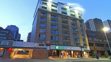 Een meerhoog hotel met een Holiday Inn Express & Suites bord, met een bakstenen gevel en meerdere balkons.