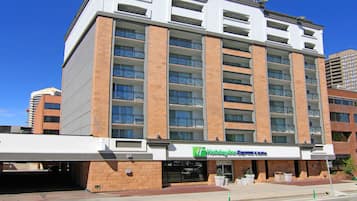 Un hotel de varios pisos con fachada plana, grandes ventanales y una entrada destacada.