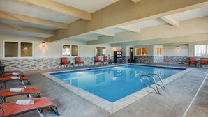 Ein großer, überdachter Pool mit Liegestühlen und einer Küchenzeile.