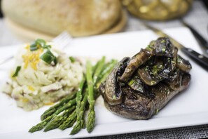 A plate with a steak topped with mushrooms, asparagus, and a side of mashed potatoes. - Crowne Plaza Saddle Brook by IHG (Saddle Brook)