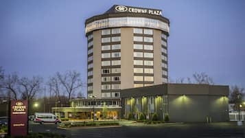Experience the iconic Crowne Plaza hotel, featuring a striking curved corner design and a welcoming entrance area.