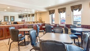 A restaurant with a bar area, wooden paneling, and large windows with curtains.