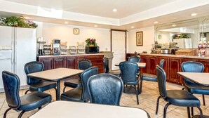 A restaurant with a bar area, wooden cabinets, and black leather chairs. - Americas Best Value Inn Paris (Paris)