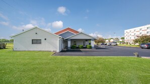 A two-story building with a flat roof, a covered entrance, and a parking lot.
