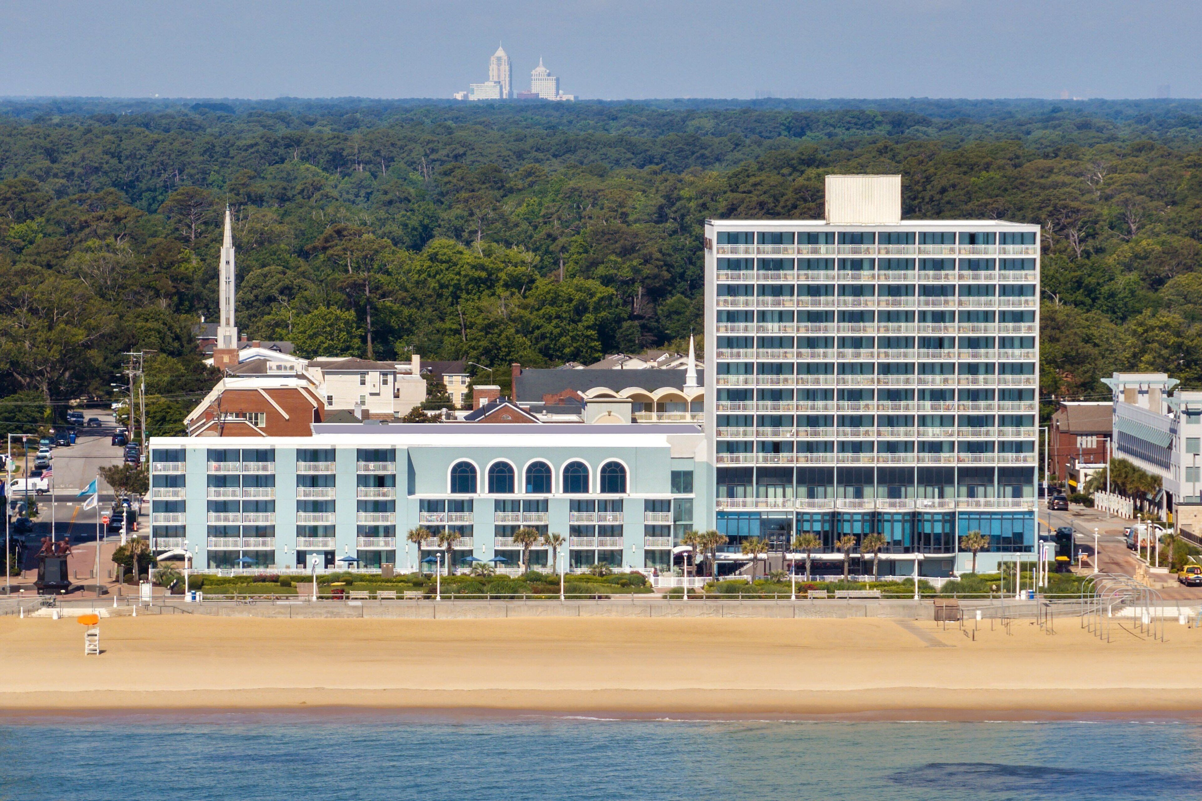 A coastal hotel with a modern building and a church in the background.
