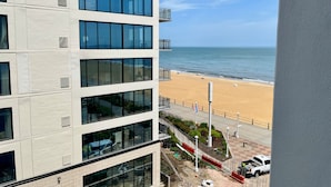 Ein mehrstöckiges Gebäude mit großen Fenstern mit Blick auf einen Strand.