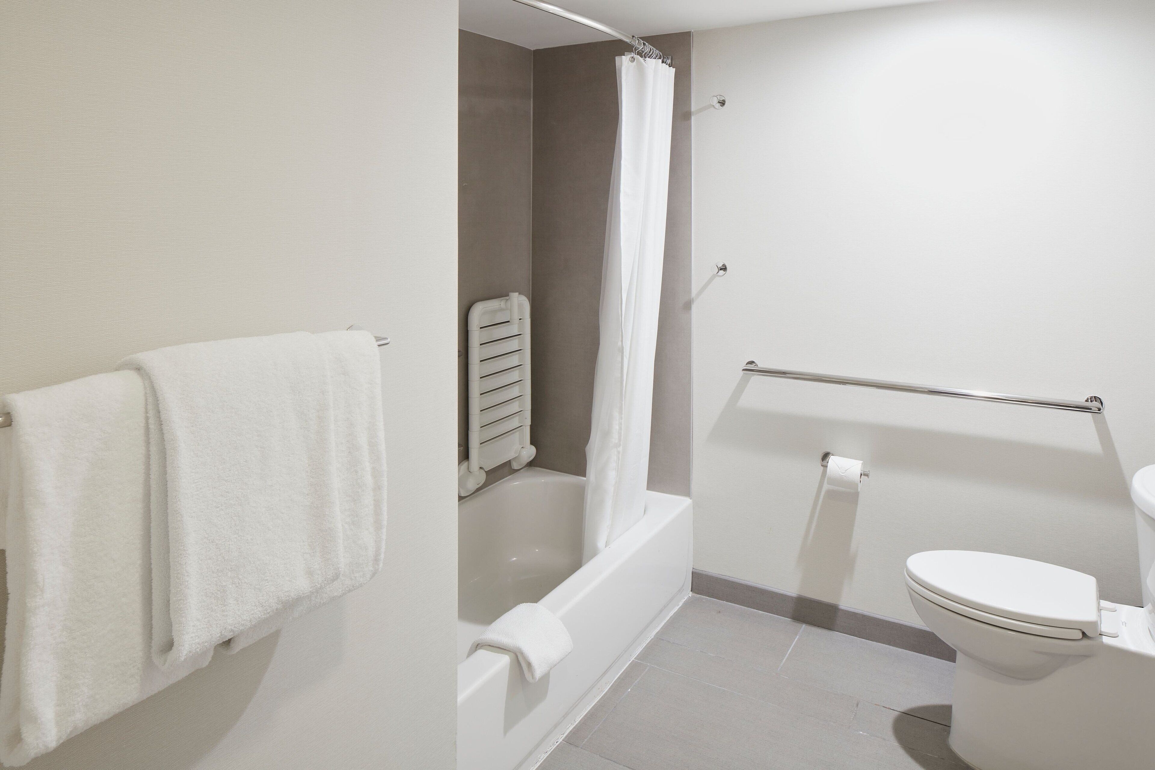 A bathroom with a bathtub, toilet, and a shower curtain.