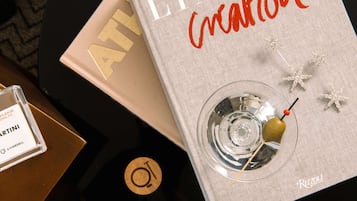 Een boek met de titel 'Liaison Creation', met een martini glas en zeester decoratie op een tafel.
