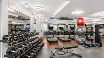 A modern gym with treadmills, dumbbells, and exercise balls.