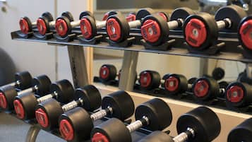 A rack of black and red dumbbells with weight markings.