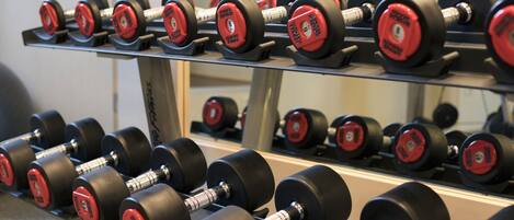 A rack of black and red dumbbells with weight markings.