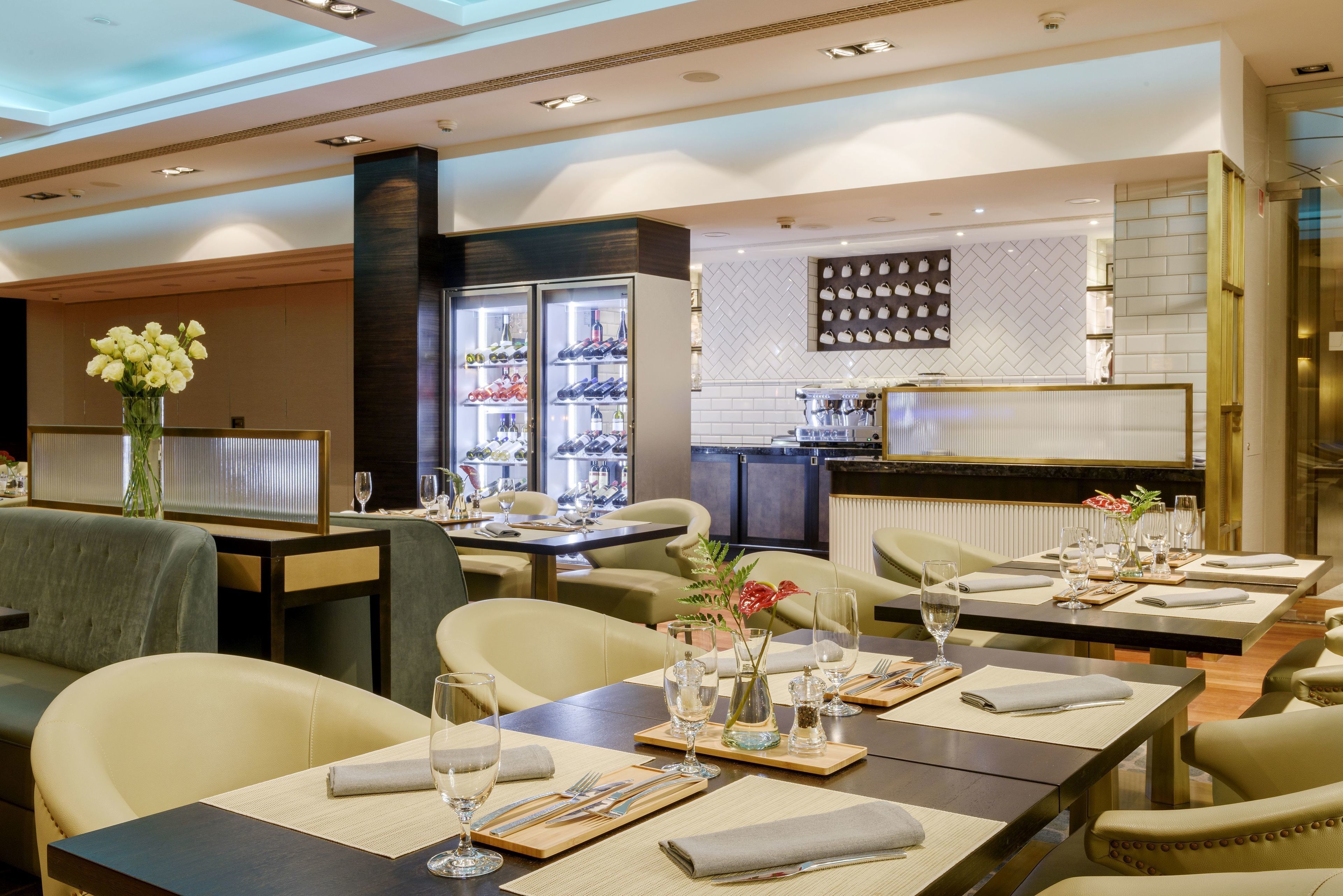 A restaurant with tables set for dining, a bar area, and a display of shoes on the wall.