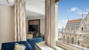 A hotel room with a large window offering a view of a historic building. - Hilton Budapest (Budapest)
