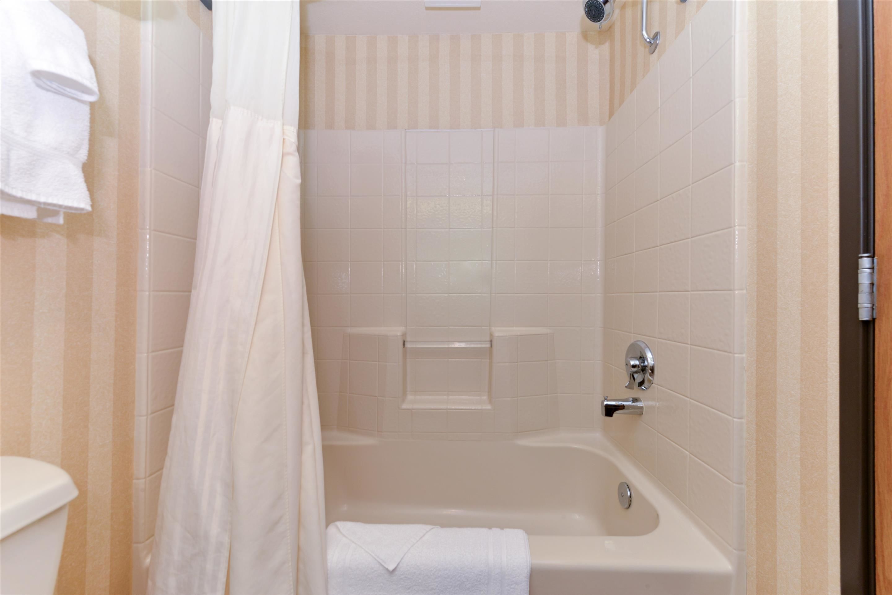 Une salle de bain avec une baignoire, un rideau de douche et des toilettes.