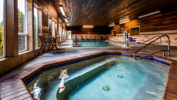 Un espace spa comprenant un jacuzzi, des sièges et une piscine.