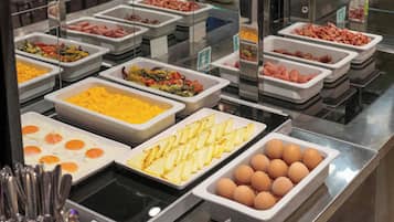 A buffet with various food items including eggs, potatoes, and meats.