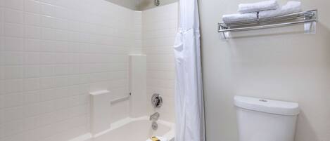 Un baño con bañera, inodoro y perchero para toallas.