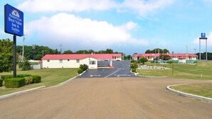 Een motel met een rood dak en een bord dat aangeeft dat het deel uitmaakt van de keten Americas Best Value Inn & Suites.