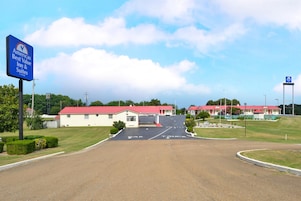 A motel with a red roof and a sign indicating it is part of the Americas Best Value Inn & Suites chain.