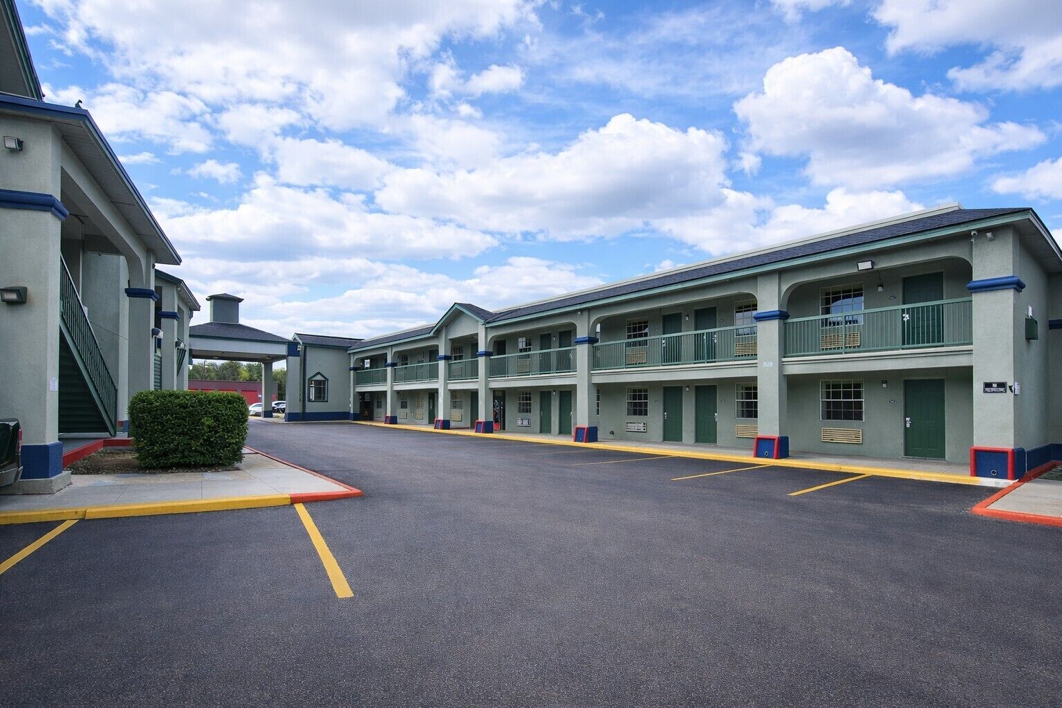 A motel with multiple floors, each with balconies and a central courtyard.