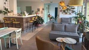 Un interior moderno con zona de bar, asientos y plantas.
