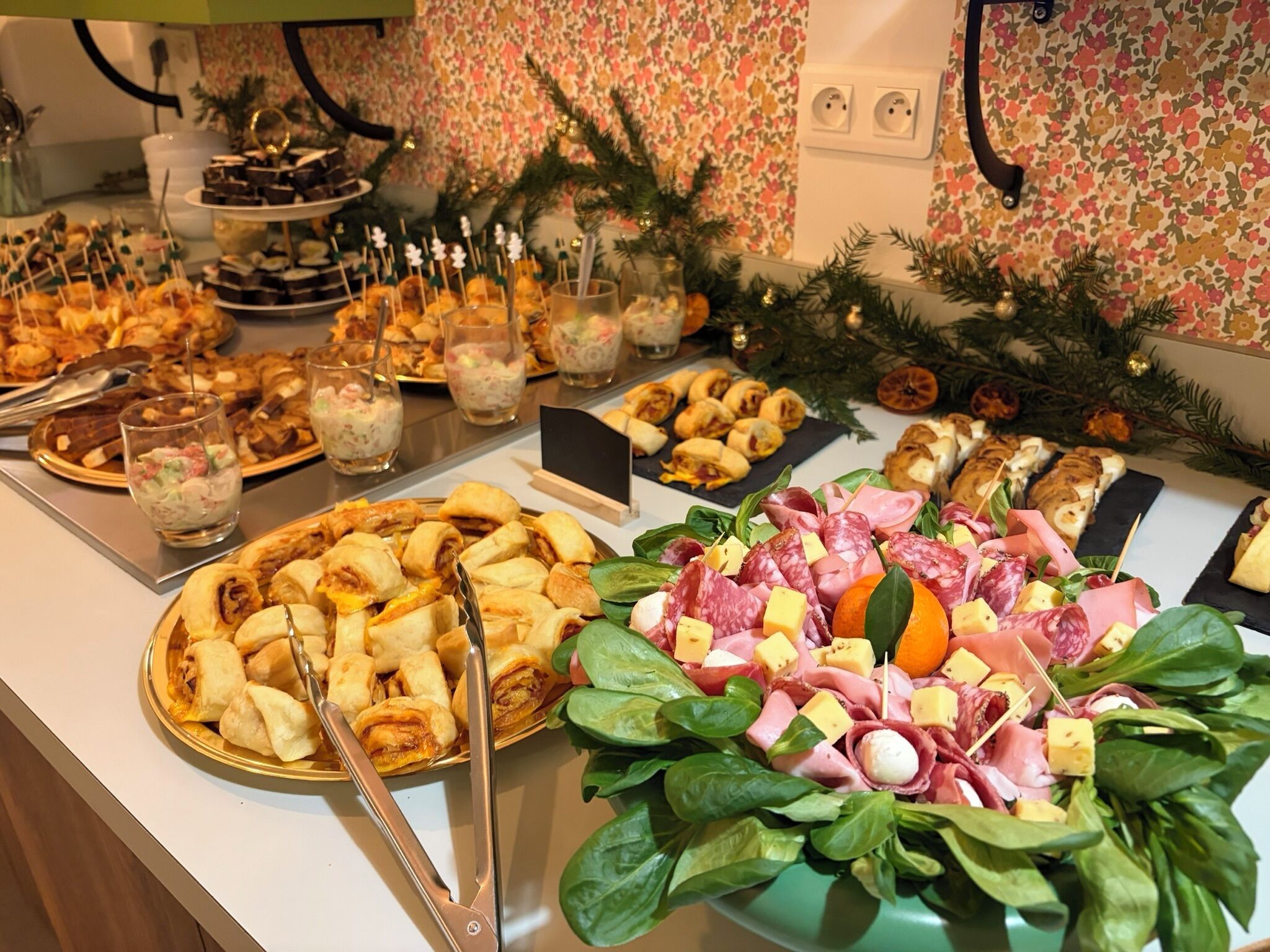 Buffet com diversas opções de comida, incluindo doces, saladas e um prato de carnes.