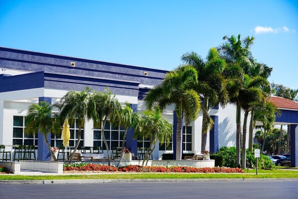 A modern building with a blue and white facade, palm trees, outdoor seating, and a 'No Parking' sign. - Clearwater Beach Sheraton Resort on Sand Key (Clearwater Beach)