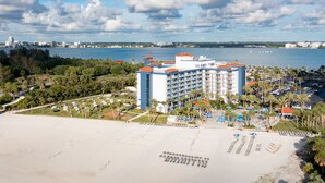 A beachfront hotel with a pool, beach chairs, and a view of the ocean. - Clearwater Beach Sheraton Resort on Sand Key (Clearwater Beach)