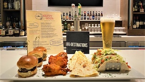Un espace bar avec un tableau affichant le menu, un verre à bière et des plats comme des hamburgers et des tacos.