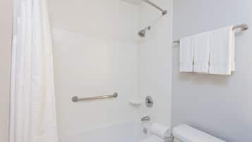Une salle de bain équipée d’une baignoire, d’une douche, de toilettes et d’un porte-serviettes.