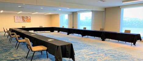 A conference room with a long table, chairs, and large windows.