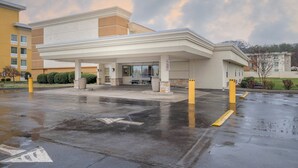A hotel with a covered parking area, a lobby entrance, and a building facade. - Red Roof Inn Knoxville Central - Papermill Road (Knoxville)