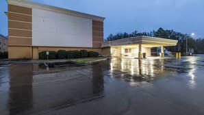 A building with a large parking lot and a covered area with a sign that reads 'CLEAR'. - Red Roof Inn Knoxville Central - Papermill Road (Knoxville)