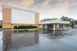 A building with a large parking lot, a covered area, and a sign indicating a location. - City Express by Marriott Knoxville (Knoxville)