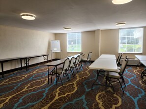 A conference room with a whiteboard, tables, chairs, and patterned carpet. - Red Roof Inn Knoxville Central - Papermill Road (Knoxville)