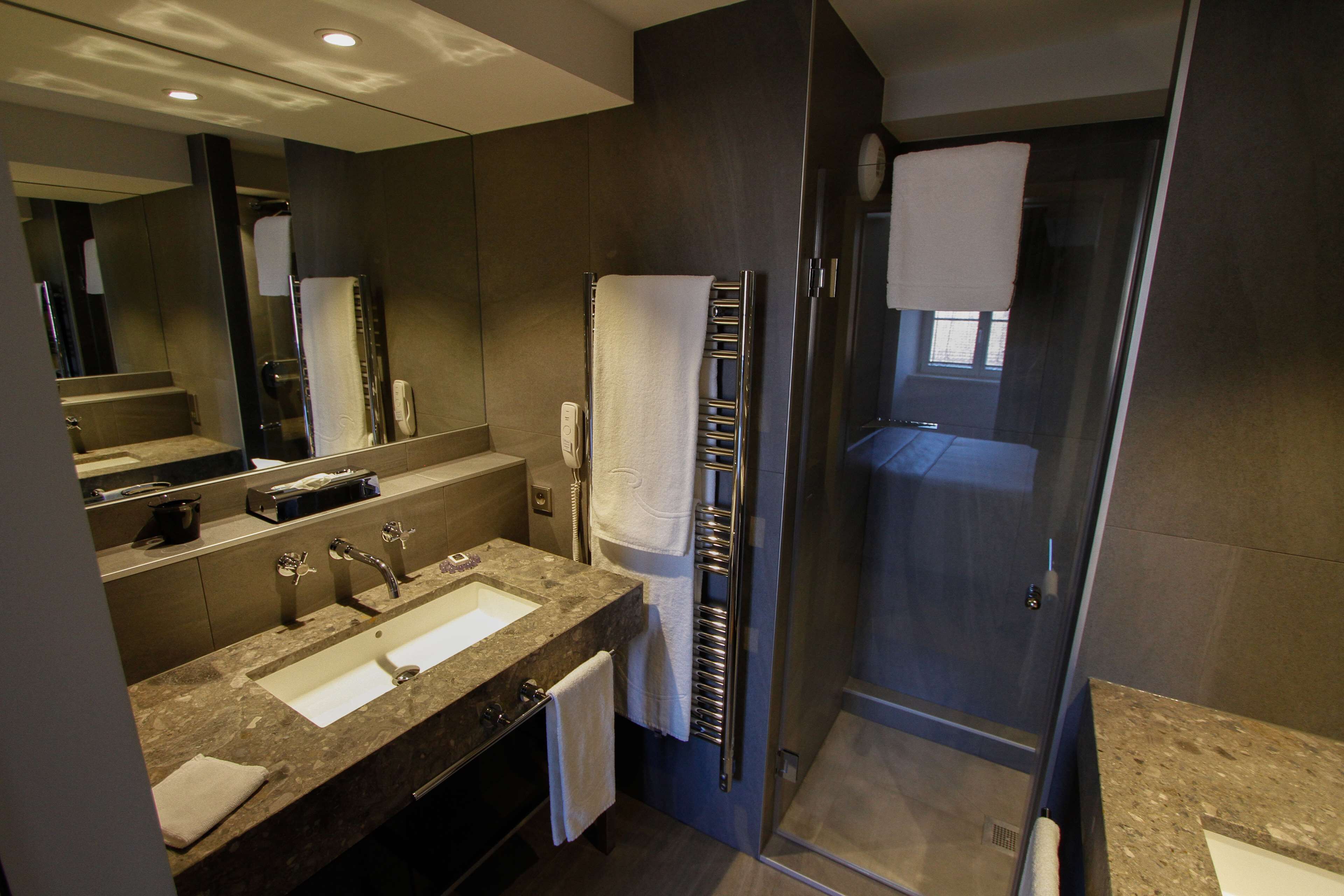 Une salle de bain moderne dotée d’un meuble-lavabo à deux vasques, d’une cabine de douche en verre et d’un grand miroir.