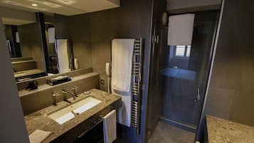Une salle de bain moderne dotée d’un meuble-lavabo à deux vasques, d’une cabine de douche en verre et d’un grand miroir.