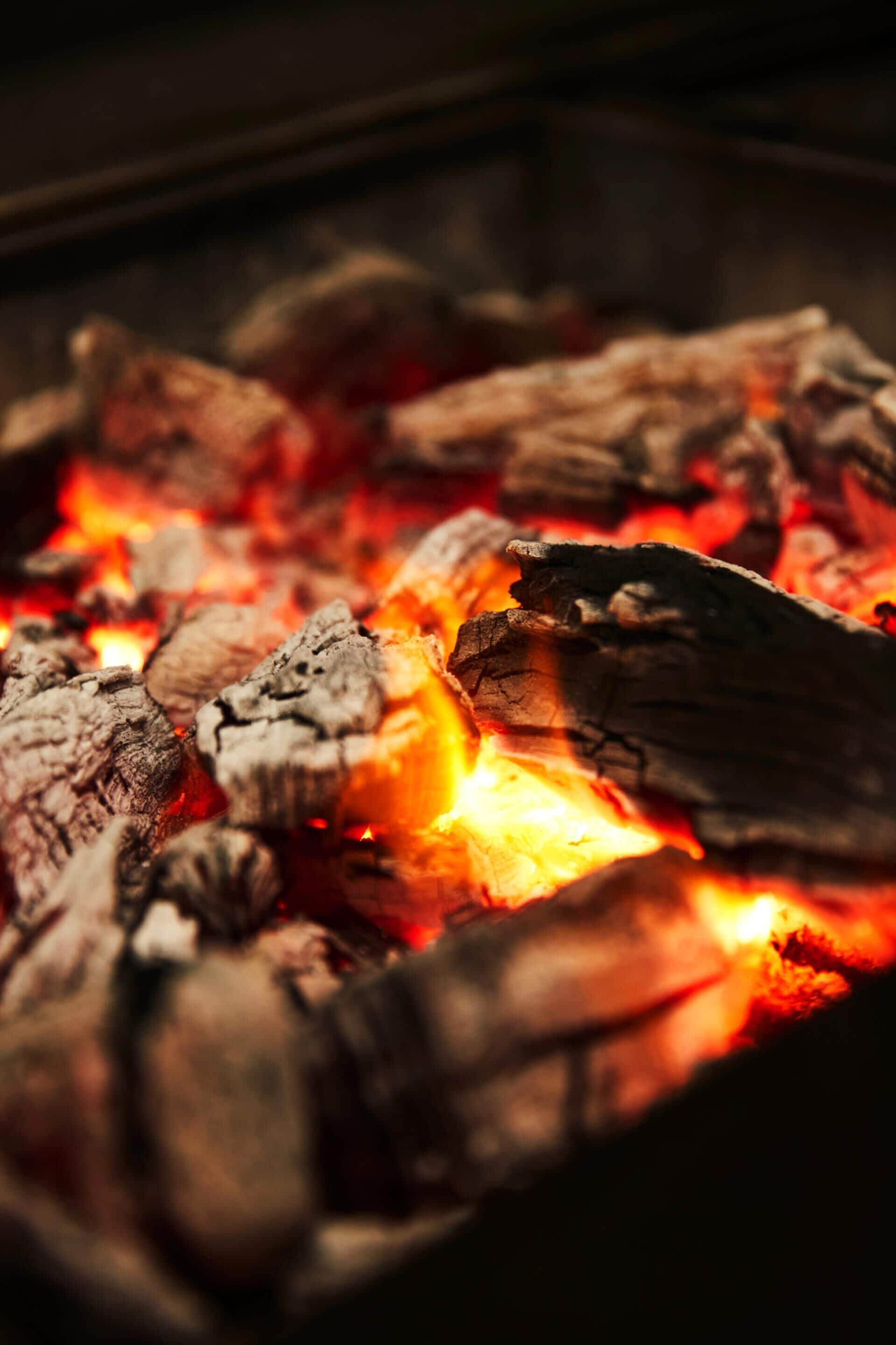 Close-up de carvão em brasa, com brasas incandescentes.