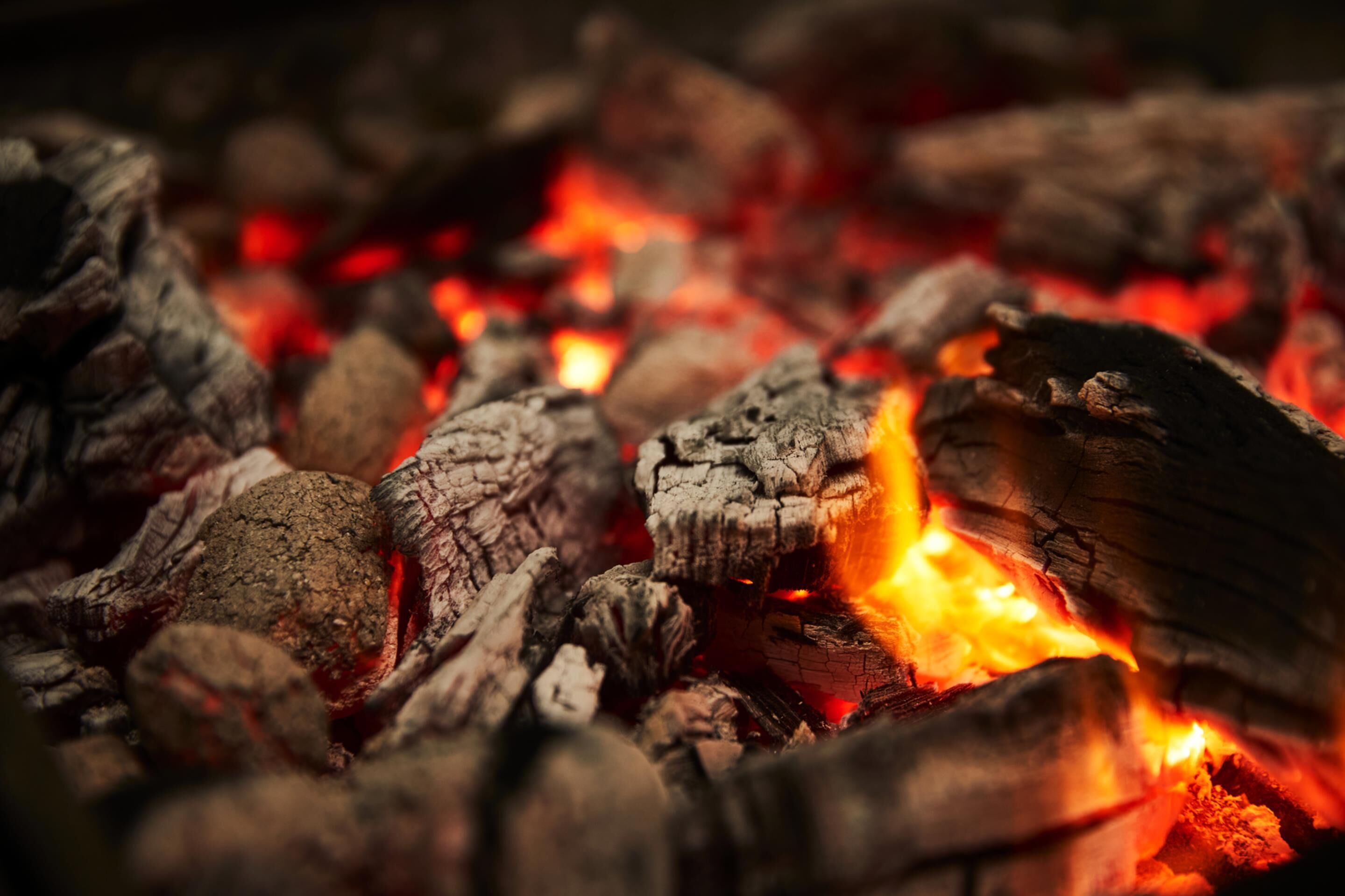 A close-up of burning charcoal with glowing embers.