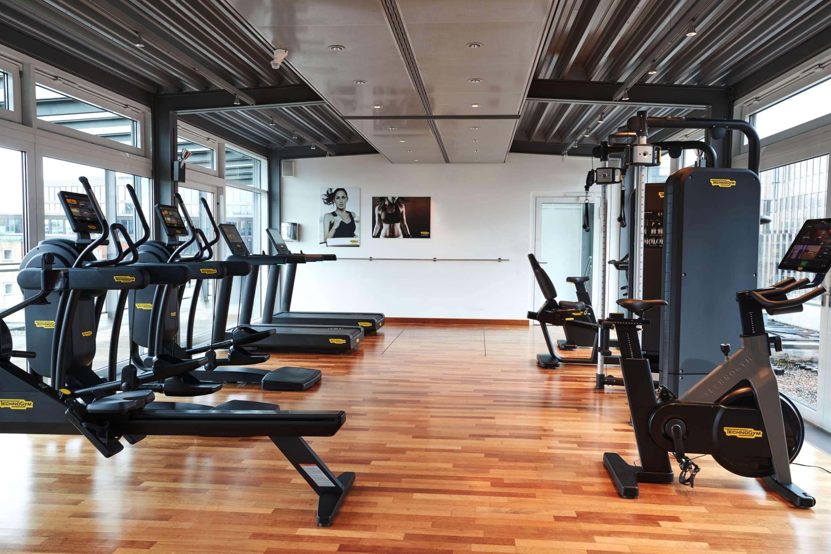 A gym with treadmills, elliptical machines, and a stationary bike.